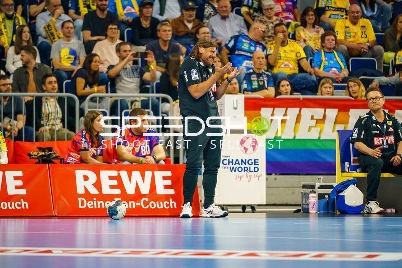 Trainer gestikuliert am Spielfeldrand