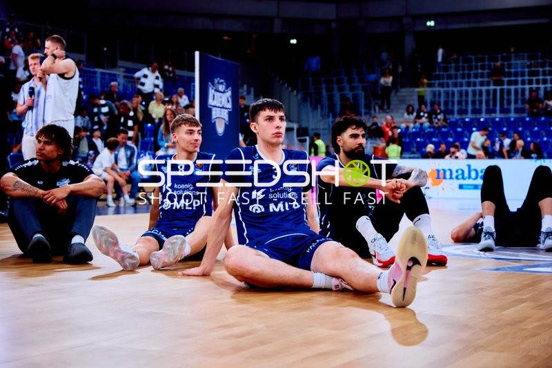 Spieler sitzen entspannt auf dem Spielfeld