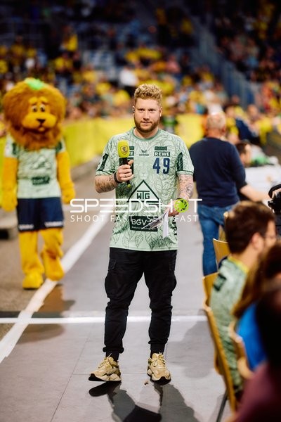 Moderator mit Mikrofon auf dem Spielfeld