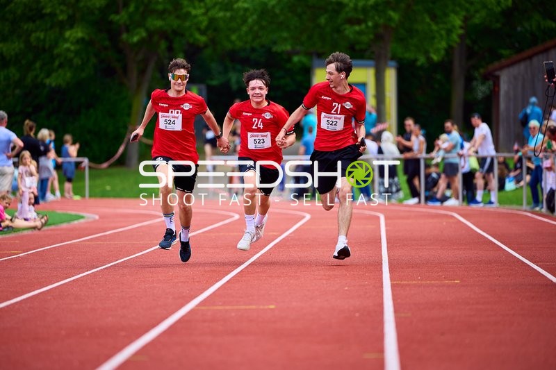 TVE Sommerlauf Edingen 2025: Läufer mit den Startnummern 522, 523 und 524 laufen gemeinsam auf der Laufbahn im TVE Sportzentrum in Edingen.