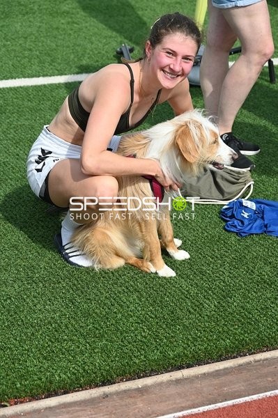 Athletin mit Hund am Spielfeldrand