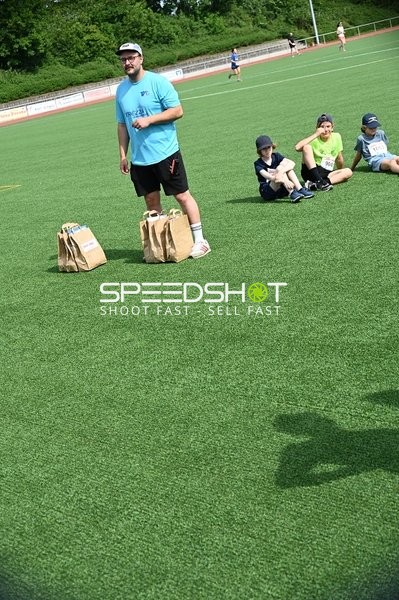 Trainer und Kinder auf dem Sportplatz