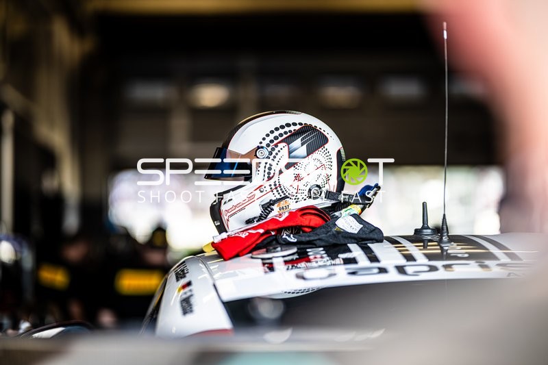 Helm auf Fahrzeugdach in Boxengasse