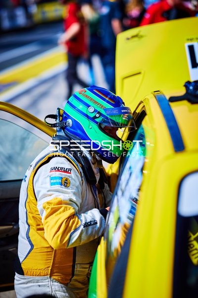 Rennfahrer neben Fahrzeug in Boxengasse