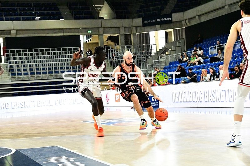 Tommy Kuhse (12; Rasta Vechta) dribbelt, Tre Mitchell (3; JL Bourg Basket) verteidigt