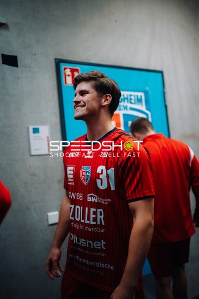 Alexander Pfeifer (31; SG BBM Bietigheim) lächelt im Mannschaftsbereich