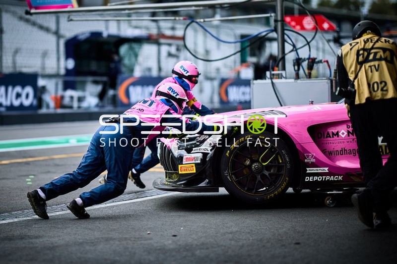 Mechaniker schieben Fahrzeug in der Boxengasse