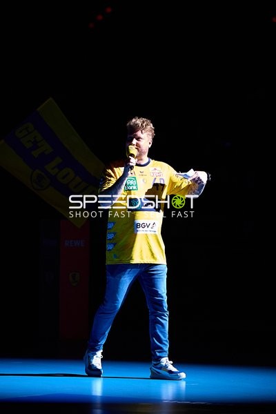 Person spricht in Mikrofon auf dem Spielfeld