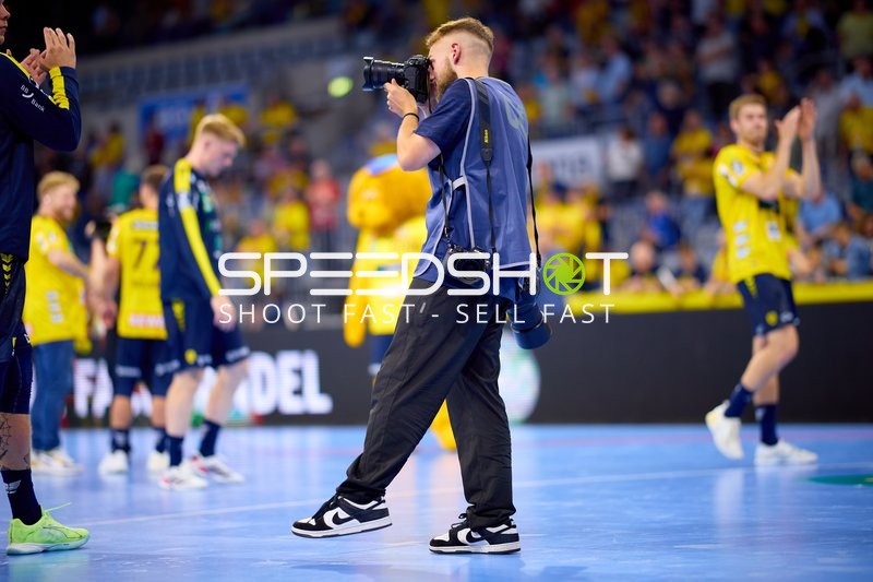 Spieler und Fotograf auf dem Spielfeld