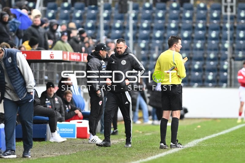 Schiedsrichter und Trainer an Seitenlinie