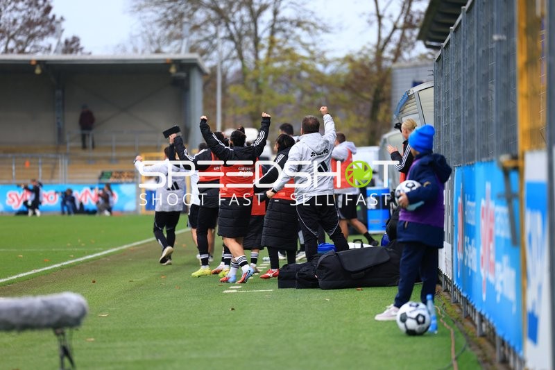 Teammitglieder feiern am Spielfeldrand