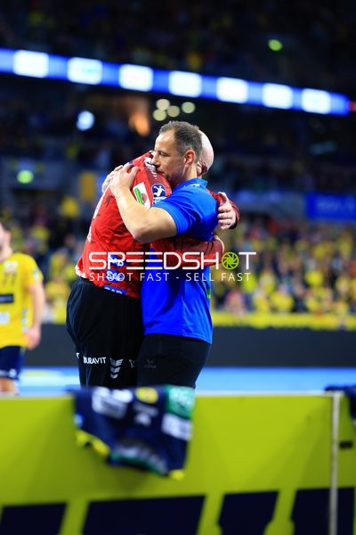 Handball-Szene mit zwei Spielern in Umarmung