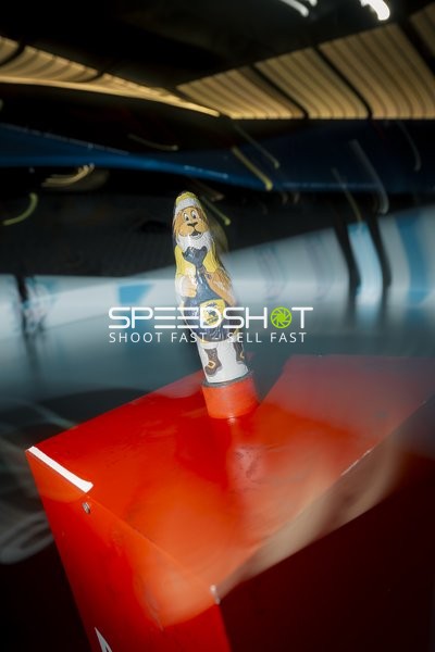 Maskottchenfigur auf rotem Kasten