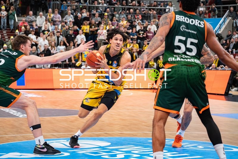 Lenny Anigbata (12; MHP Riesen Ludwigsburg) mit Ball gegen Marten Linßen (12; Gladiators Trier) und Eli Brooks (55; Gladiators Trier)