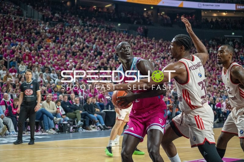 Isiaha Mike (22; FC Bayern Basketball) mit Ball gegen Kur Jongkuch (15; Telekom Baskets Bonn)