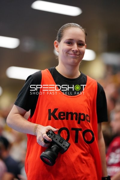 Person mit Kamera in oranger Weste