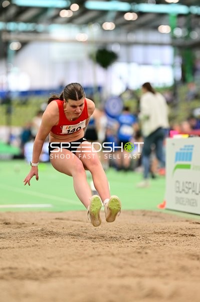 Athletin mit Startnummer 140 beim Weitsprung