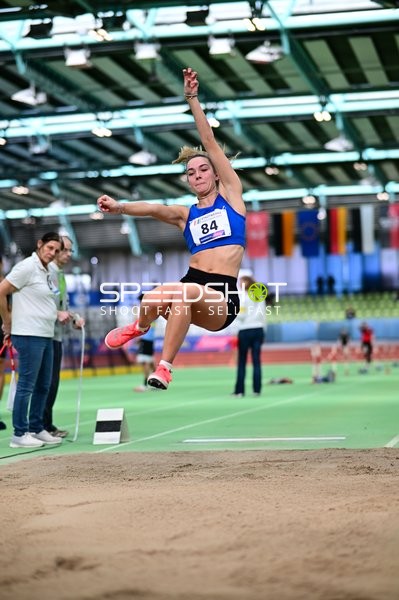 Athletin mit Nummer 84 beim Weitsprung