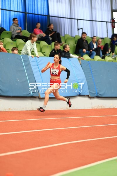 Athletin mit Staffelstab auf Bahn