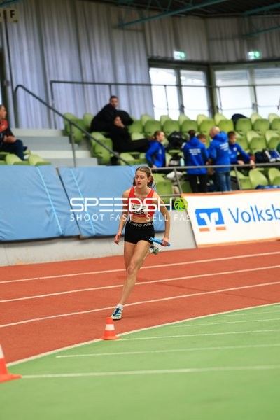 Athletin mit Staffelstab in Aktion