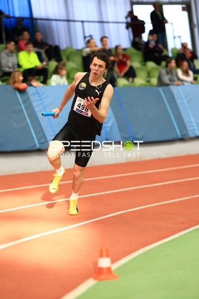 Athlet mit Staffelstab auf Bahn