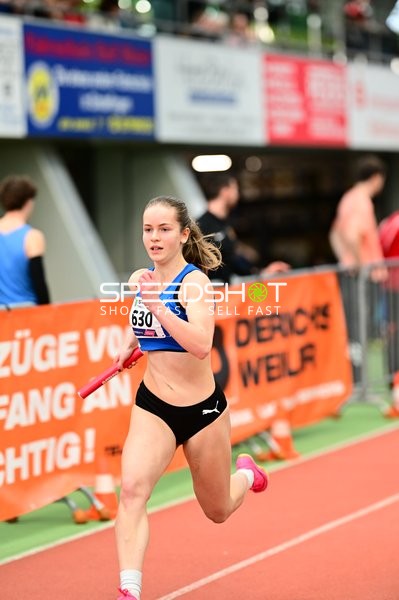 Athletin mit Staffelstab in Aktion