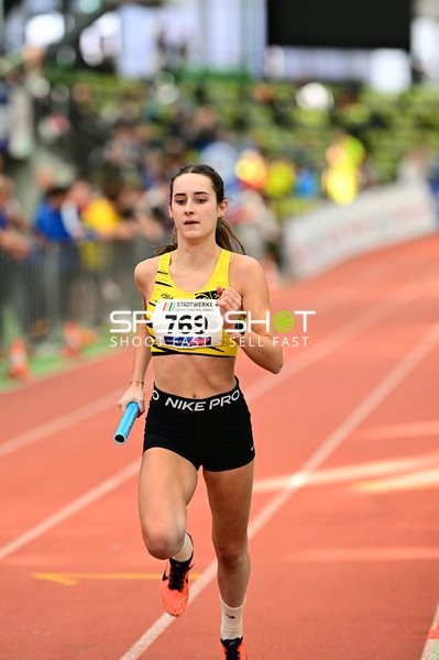 Athletin mit Staffelstab in Aktion