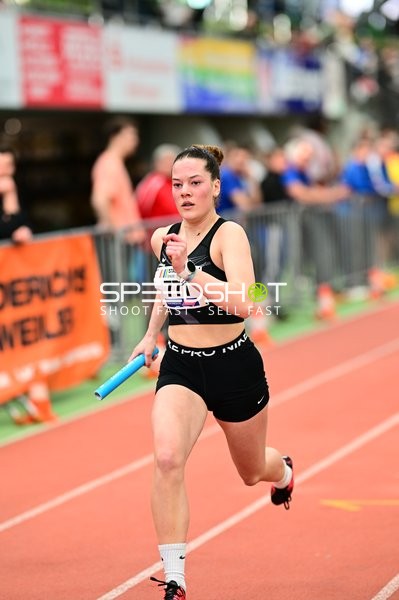 Athletin mit Staffelstab in Aktion