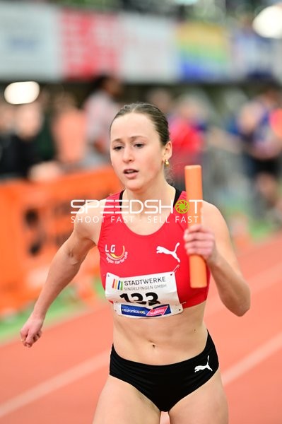 Athletin mit Staffelstab in Aktion