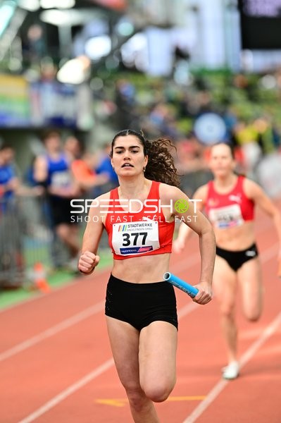 Athletin mit Staffelstab in Aktion