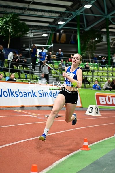 Athletin mit Staffelstab in Aktion