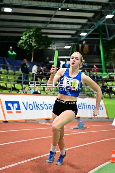 Athletin mit Staffelstab in Aktion