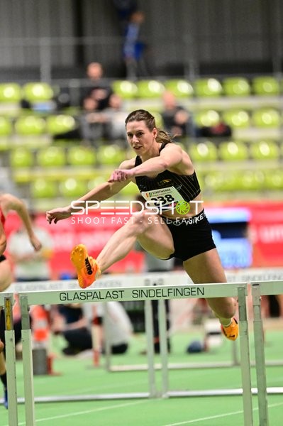 Athletin mit Nummer 238 überspringt Hürde