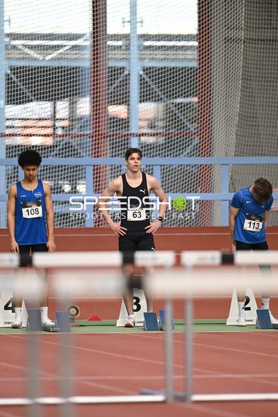 Athleten mit Startnummern an Startblöcken