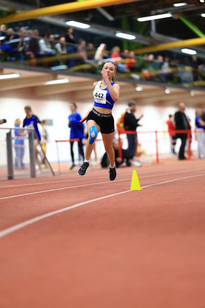 Athletin mit Staffelstab in Aktion