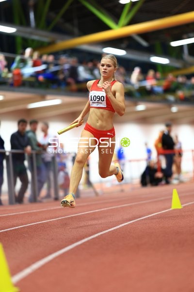 Athletin mit Staffelstab in Aktion