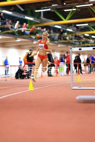 Athletin mit Staffelstab in Aktion