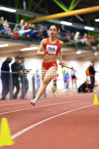 Athletin mit Staffelstab in Aktion