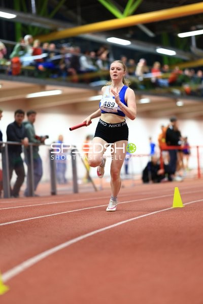 Athletin mit Staffelstab in Aktion