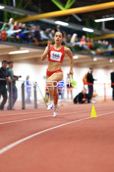 Athletin mit Staffelstab in Aktion