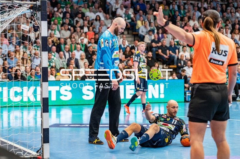 Handball, Bundesliga, Saison 25/26, Spieltag 29, Göppingen (grün), Löwen (blau-gelb), Mike Jensen #20 (links, Löwen), Lukas Sandell #11 (Boden, Löwen)