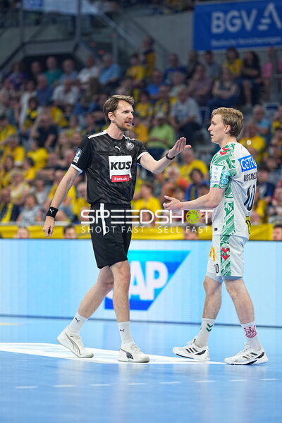 Schiedsrichter im Zweikampf mit SC Magdeburg Spieler in der SAP Arena