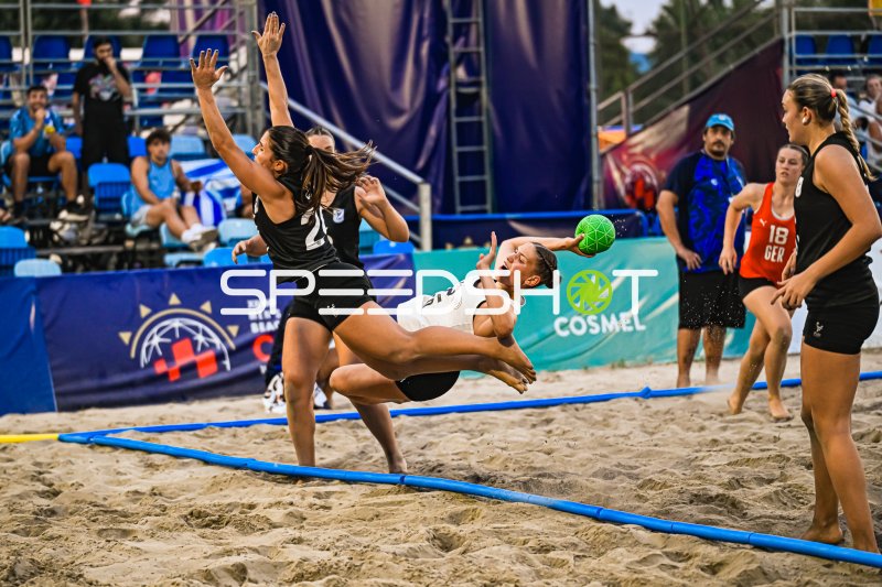 Deutsche Beachhandballerin beim Drehwurf gegen USA-Abwehr