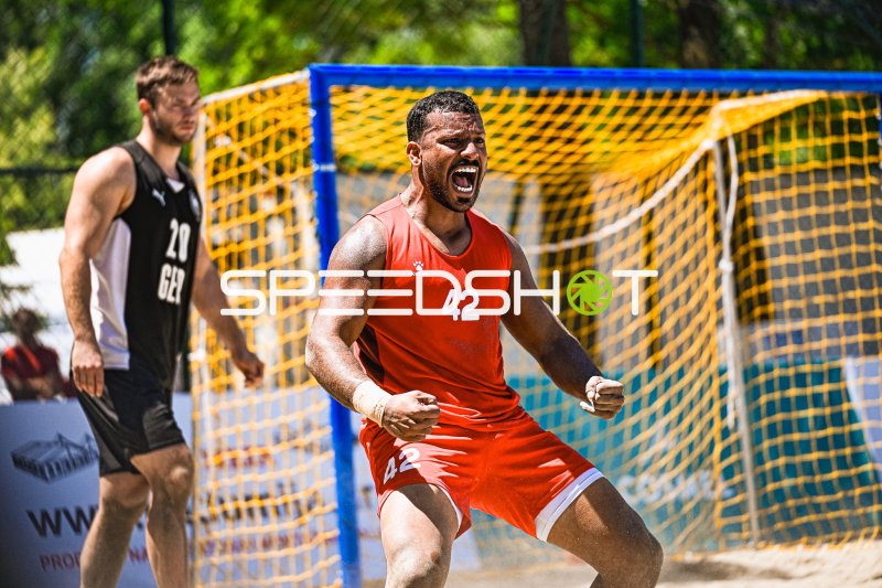 Jubelnder Spieler (#42) vor dem Tor beim Beachhandball