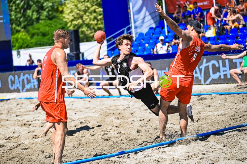 Lennart Wörmann (#2; Deutschland Beachhandball) im Wurf gegen dänische Abwehr