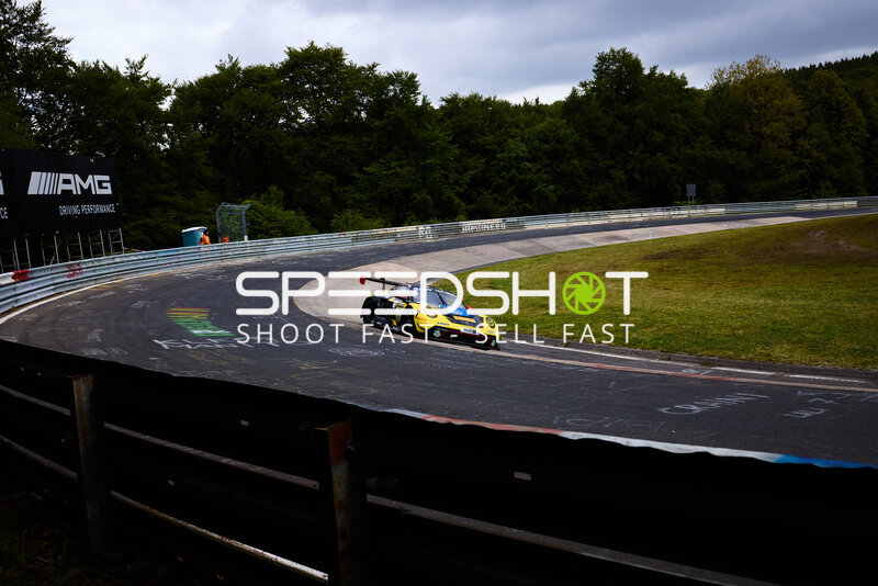 Gelb-schwarzer Porsche #91 von Reiter Engineering in der Nordschleife-Kurve
