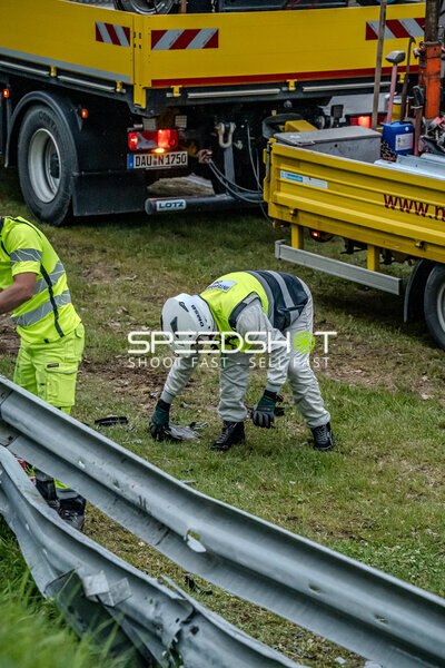 Streckenposten beseitigen Trümmer nach Unfall an der Leitplanke