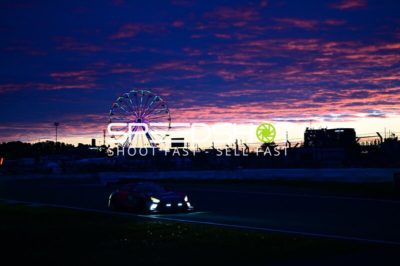 Rennfahrzeug bei Sonnenuntergang am Nürburgring mit leuchtendem Riesenrad