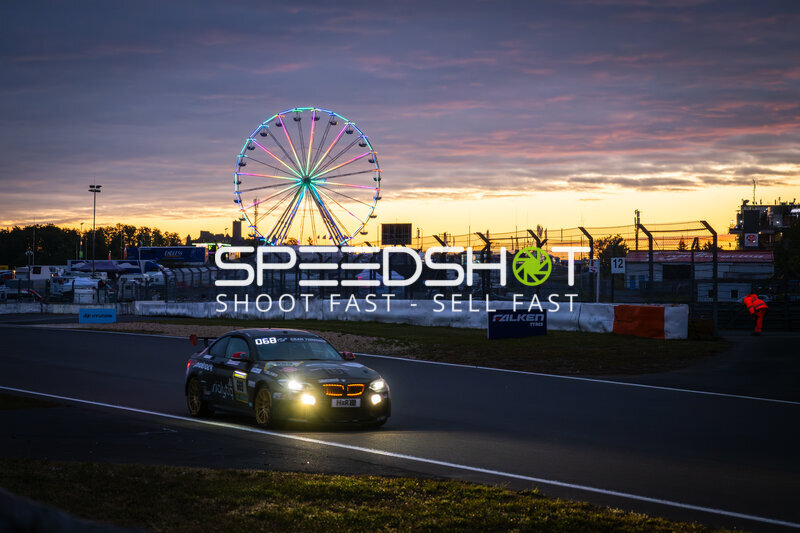 BMW #068 bei Sonnenuntergang am Nürburgring mit leuchtendem Riesenrad