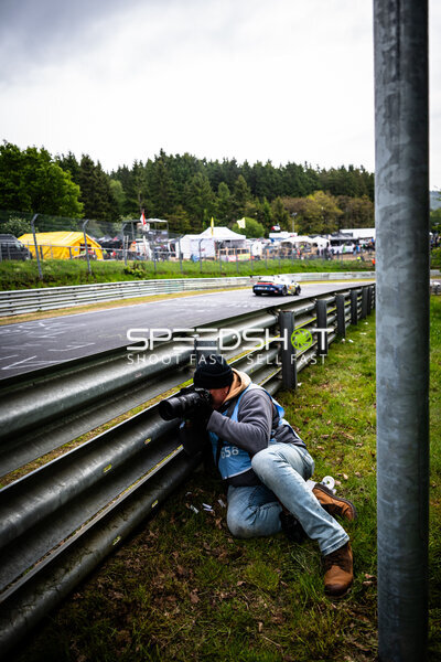 Fotograf liegt an der Leitplanke und fotografiert beim 24h Nürburgring